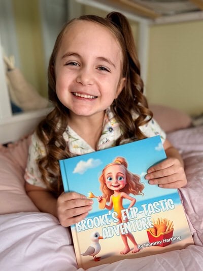 Smiling child holding a personalized storybook featuring their own name and photo
